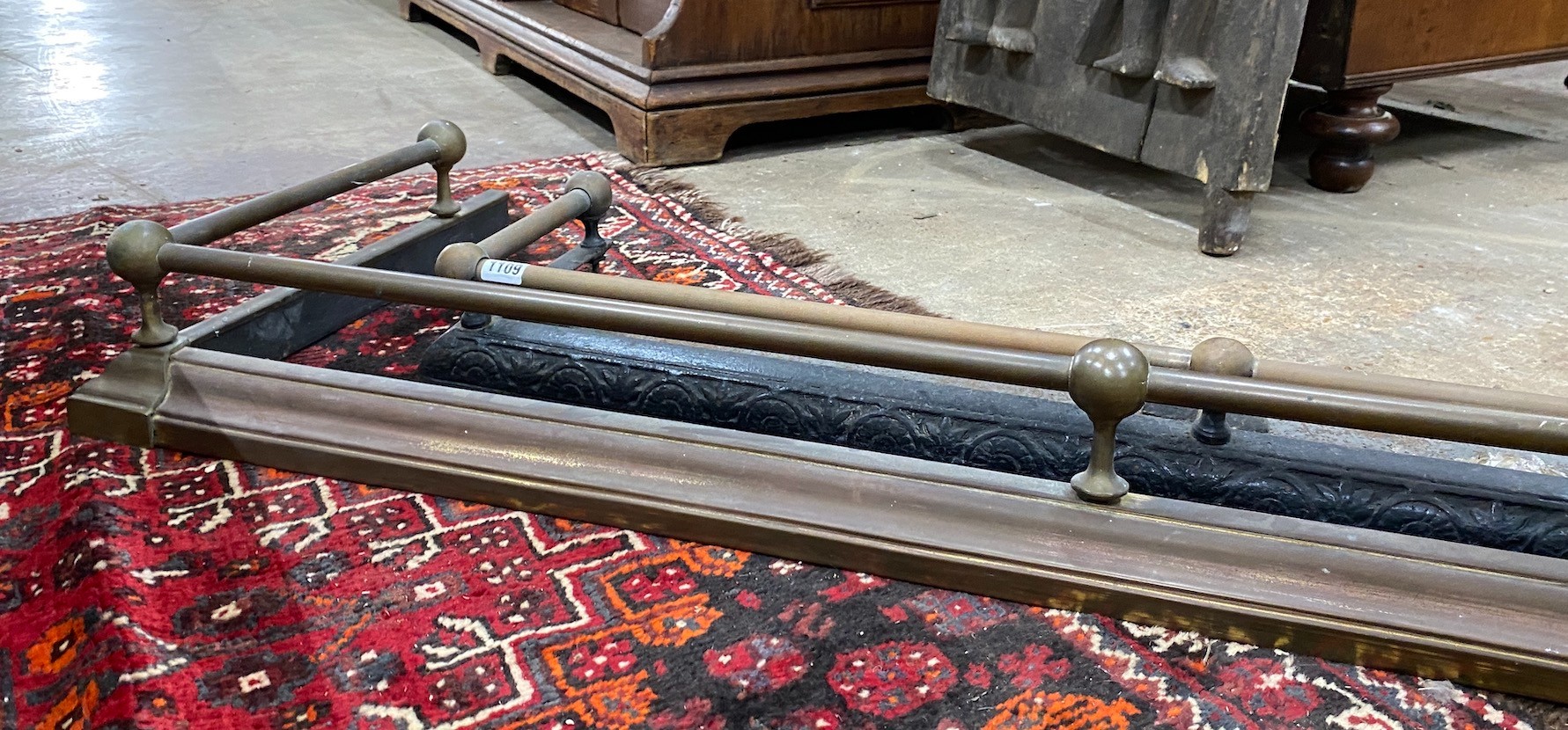 A Victorian iron and brass fender, length 104cm, together with a larger later brass fender